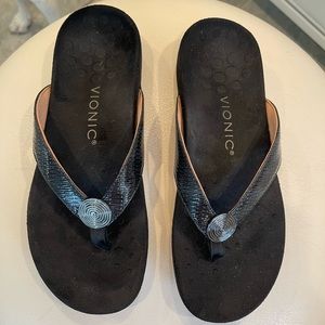Vionic black sandals with fabric footbed and decorative straps.